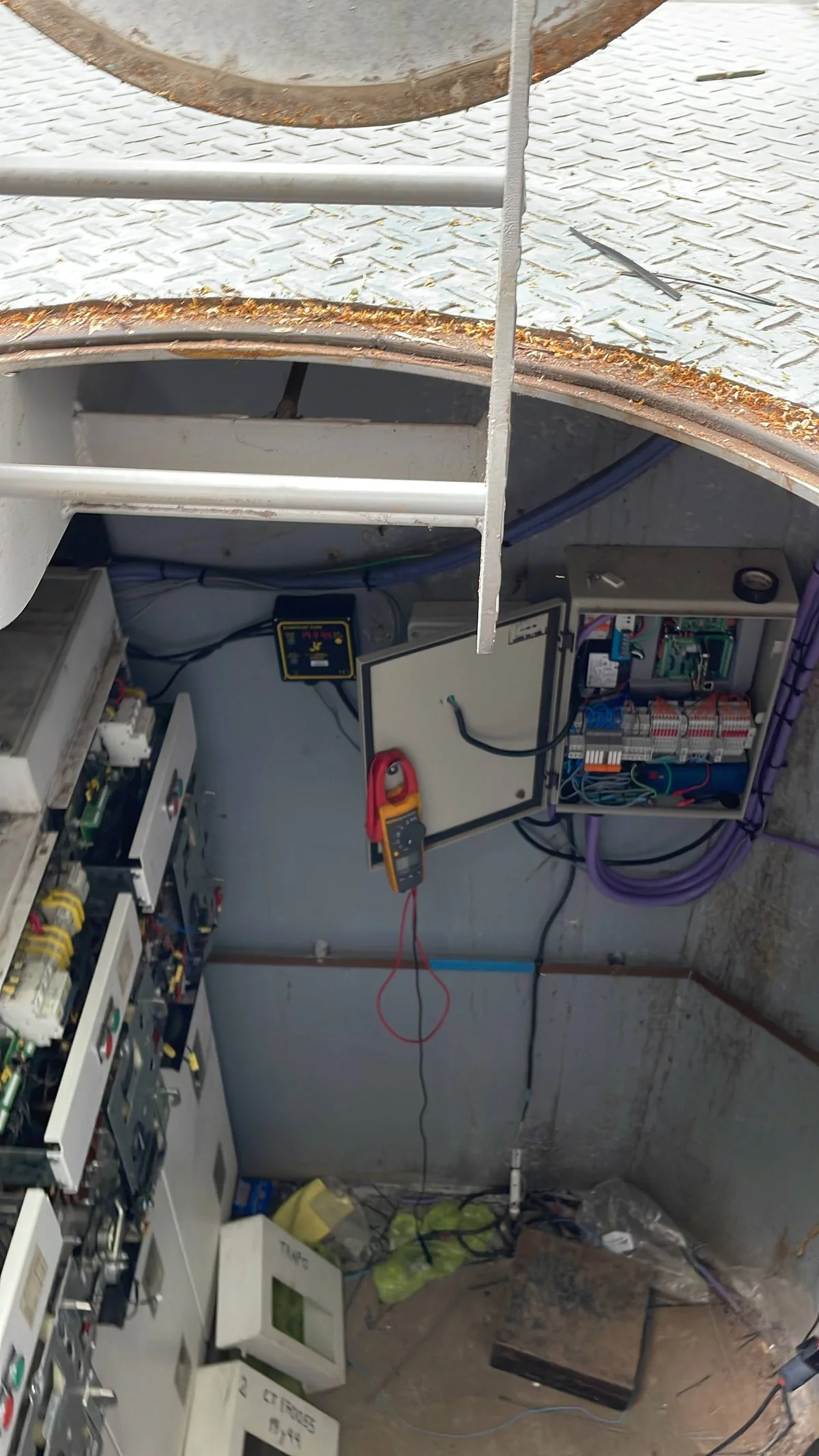 Tablero de control instalado dentro de una cámara subterránea de media tensión, visto desde la boca de acceso